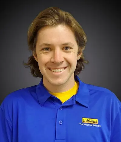 Headshot of Jonathan VanDeberg in a blue InfoWest polo against a gray backdrop.