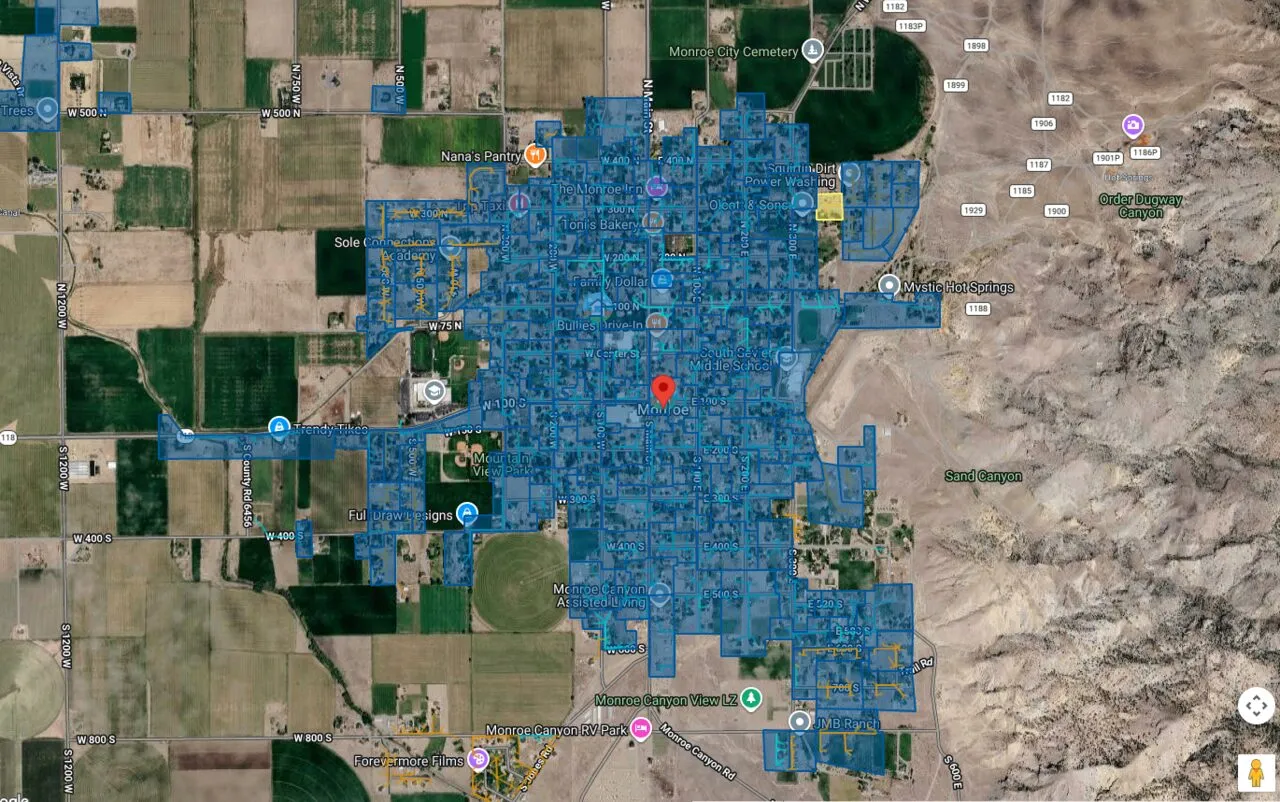 Satellite map of Monroe with the city's grid of streets shaded blue, farmland to the west and the mountains rising to the east.