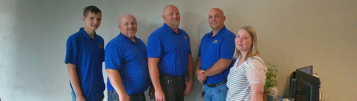 Five InfoWest staff in blue shirts standing together at the Richfield office.