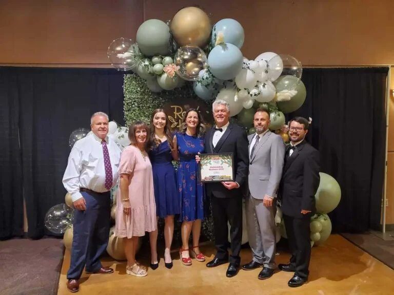 InfoWest employees holding an award at the Root for Kids gala