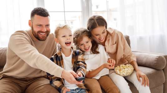 Happy family watching tv together